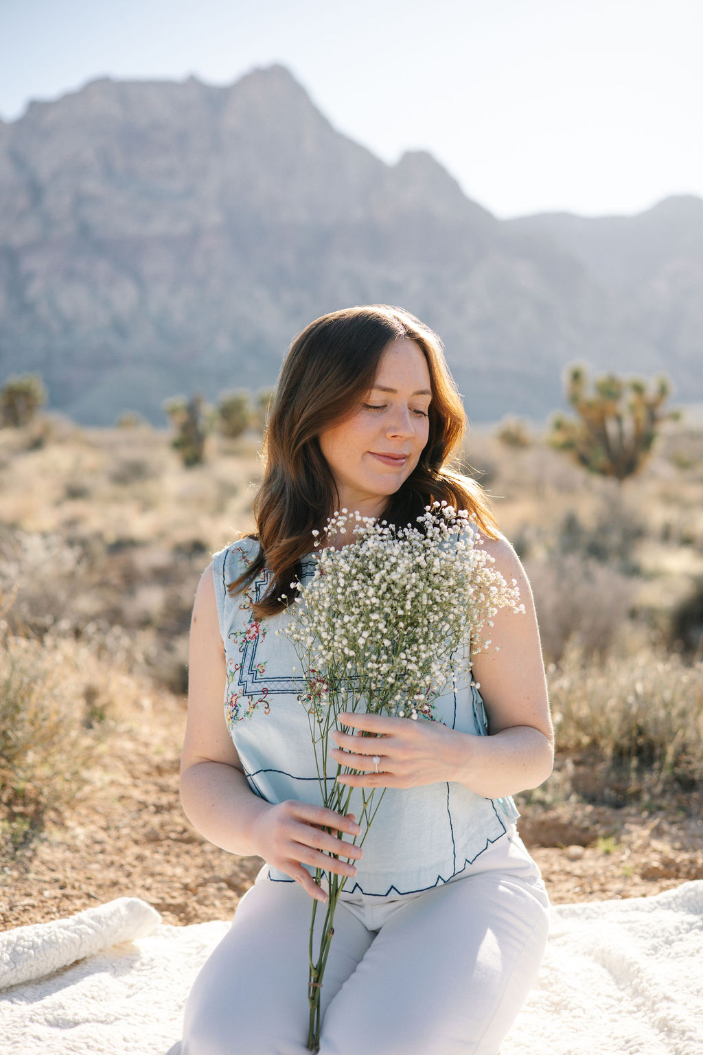 Chelsea sitting outside holding a bundle of flowers