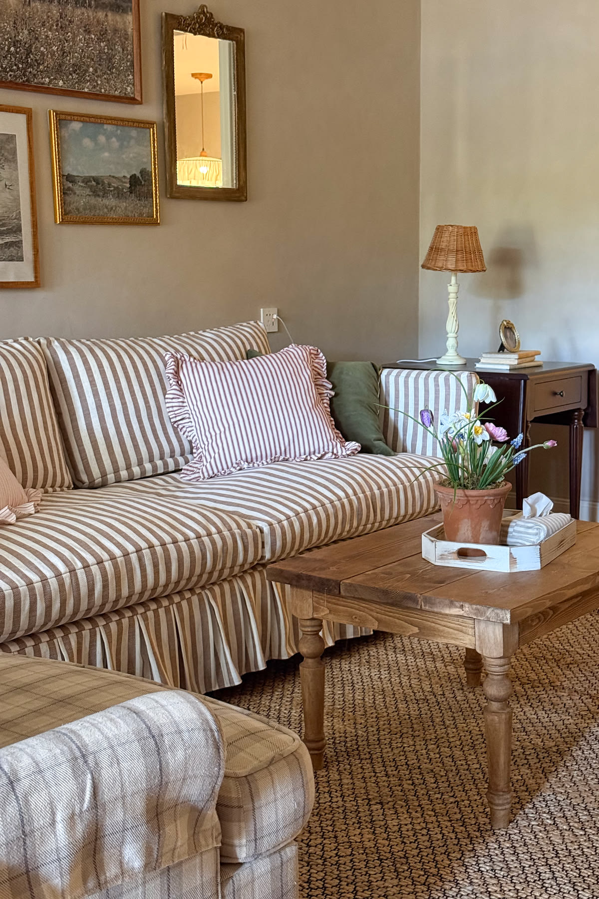 A living room with a striped sofa and warm light